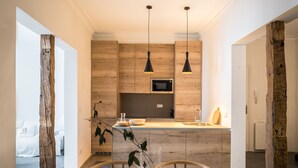 A modern kitchen with wooden cabinets, a central island, and pendant lighting. - 2 balconies 2 fireplaces WITH CHARM and SPECIAL (Madrid)