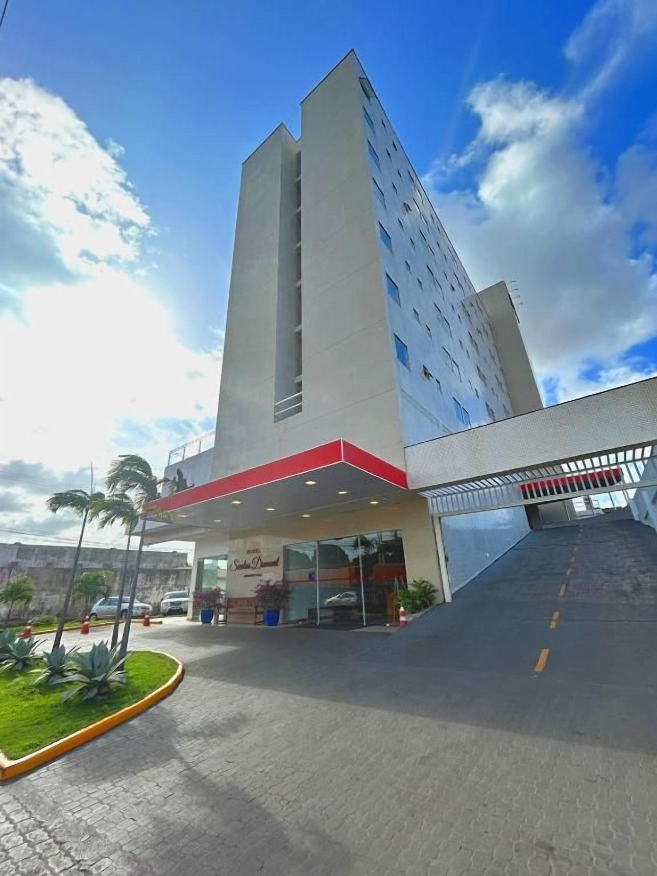 Een modern hotel met een opvallende ingang, een overdekt gedeelte en een parkeerplaats.