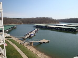 A marina with docks and boats, a bridge, and a building with a green roof.