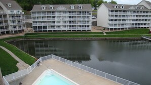 A multi-story hotel with balconies, a swimming pool, and a body of water. - Condo 331 Parkview Bay, Osage Beach Super Nice Lakefront Condo (Osage Beach)