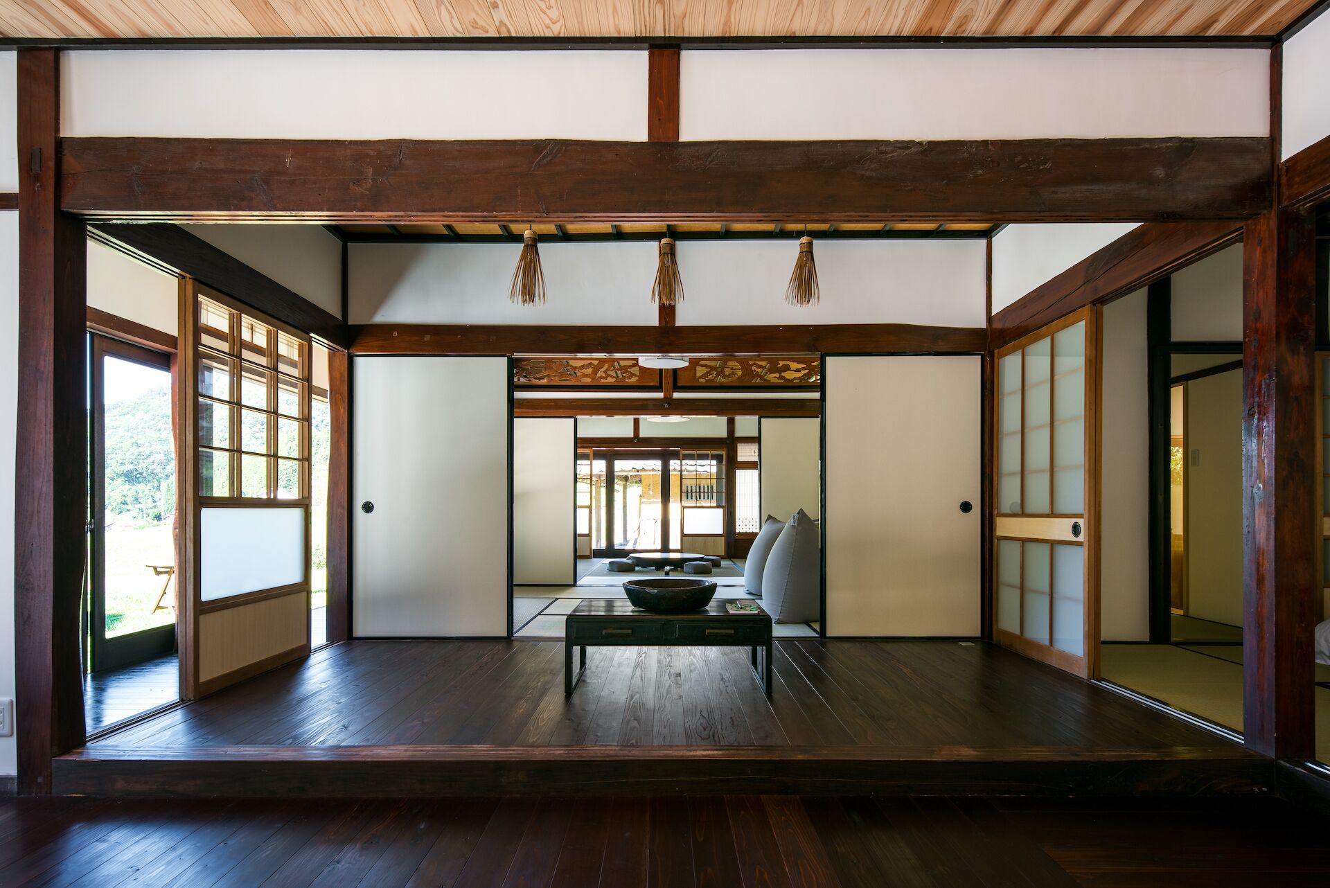 Una stanza tradizionale giapponese con pavimento in tatami, porte scorrevoli e soffitto basso.