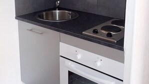 A compact kitchen with a sink, stove, and oven.