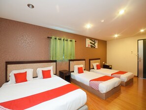Habitación de hotel con dos camas, una cortina verde, una obra de arte en la pared y piso de madera.