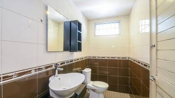 A bathroom with a white sink, a toilet, and a mirror above the sink.