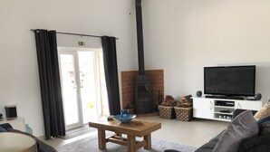 Un soggiorno con camino, televisione e divano.