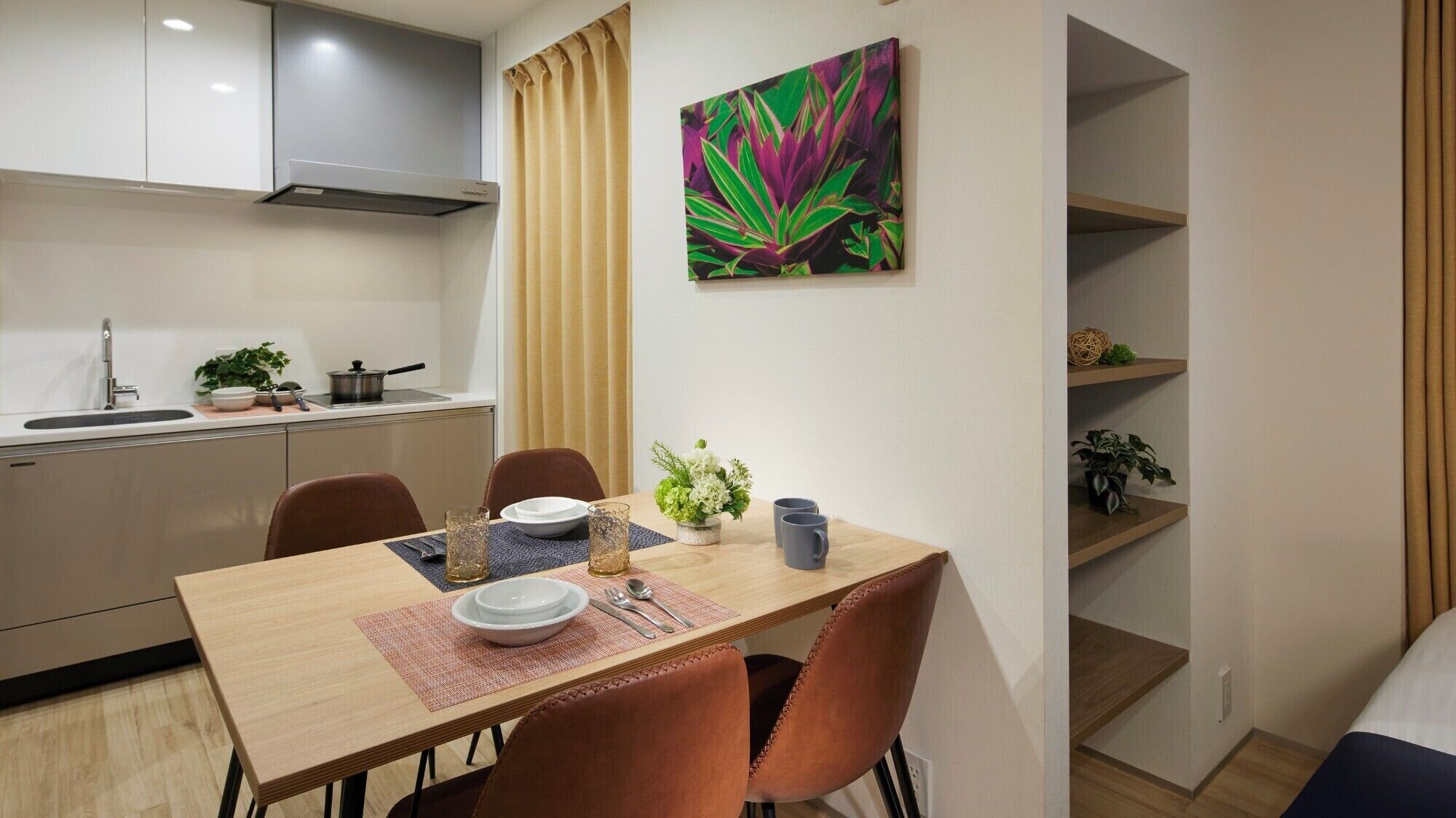 Una cocina compacta con área de comedor, una sola planta y un colorido cuadro abstracto en la pared.