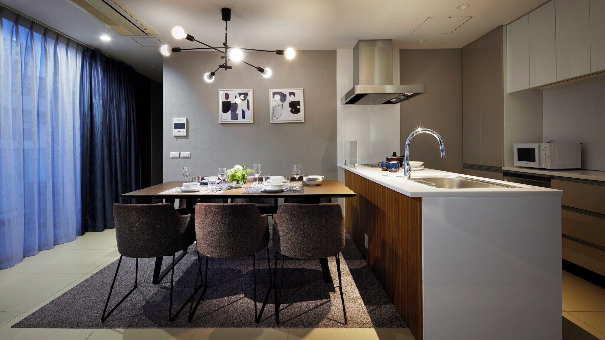 A modern kitchen with a central island, a built-in sink, and a microwave.