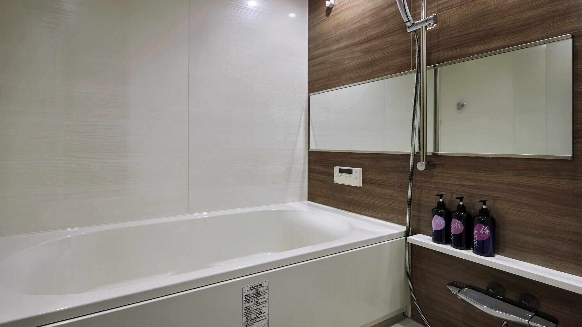 A modern bathroom with a bathtub, a wooden vanity, and a mirror.