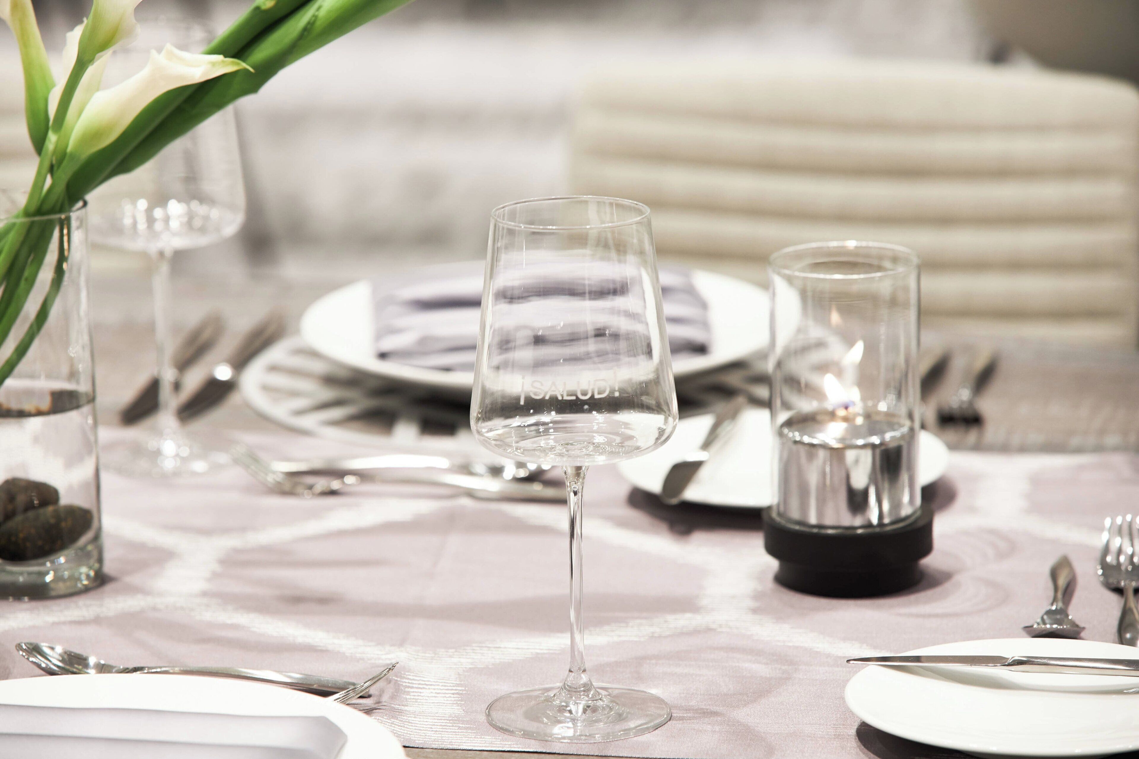 A table set for dining with clear glassware, plates, and cutlery.