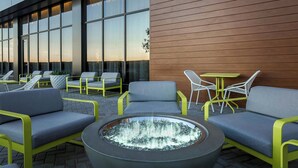 An outdoor seating area with modern chairs and a central fire feature. - AC Hotel by Marriott Dallas Frisco (Frisco)