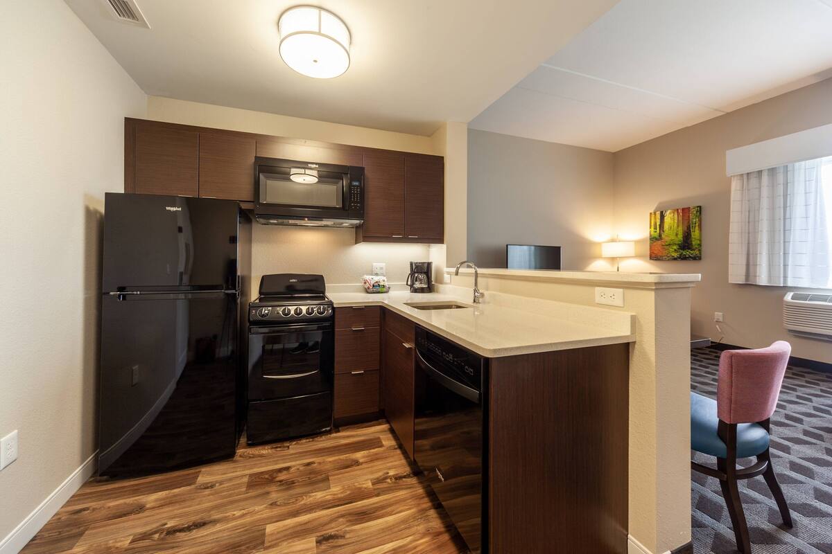 A compact kitchen with a refrigerator, stove, microwave, and dishwasher.
