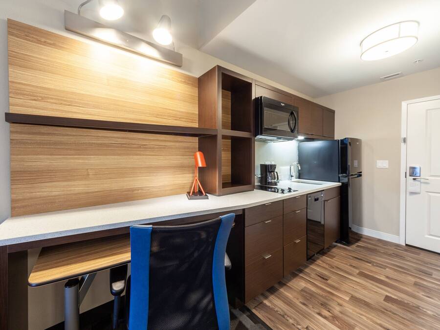 Una cocina moderna con armarios de madera, un refrigerador de acero inoxidable y un microondas.