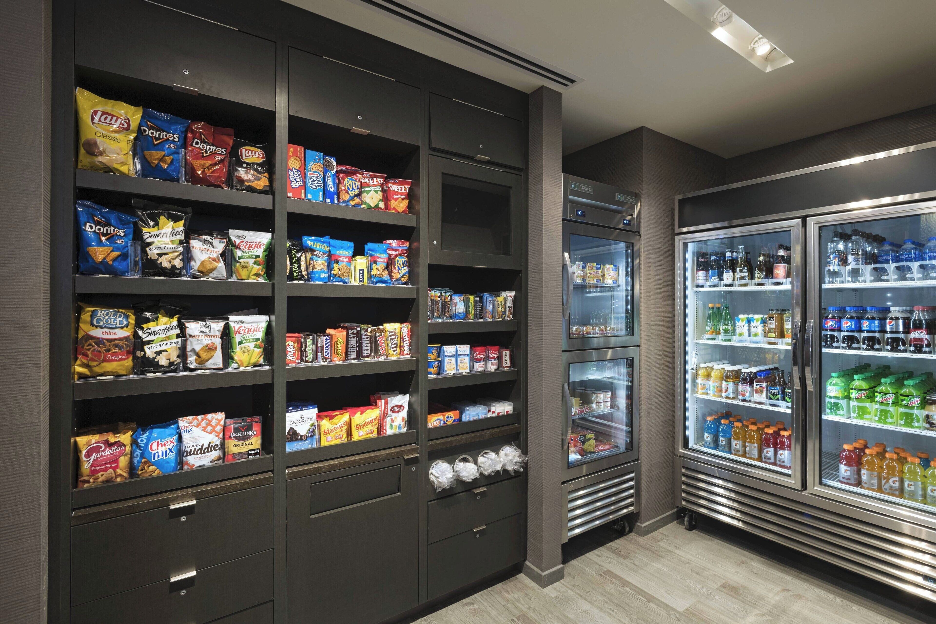 A snack and beverage refrigerator stocked with various brands and types of snacks and drinks.