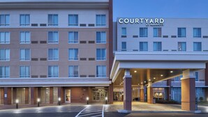 A Courtyard by Marriott hotel with a modern facade, multiple floors, and a well-lit entrance.