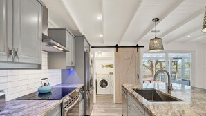 Una cocina moderna con electrodomésticos de acero inoxidable, encimera de mármol y vistas al exterior.