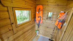 A cabin interior with wooden walls, a window, a small window, and a door. - Sieralahden lomakylä, mökki 2 by Interhome (Savonlinna)