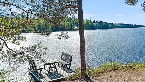 A wooden dock with two chairs extending over a body of water, surrounded by trees and a clear sky. - Sieralahden lomakylä, mökki 2 by Interhome (Savonlinna)