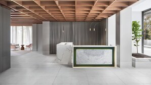 A modern reception area with a marble reception desk, wooden ceiling beams, and a large window with a view of the outdoors. - Element by Marriott Melbourne Richmond (Burnley)
