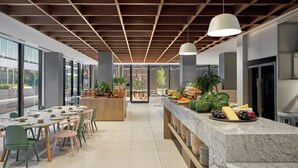 A modern kitchen with a marble countertop, wooden ceiling, and large windows. - Element by Marriott Melbourne Richmond (Burnley)