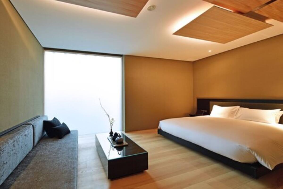 A modern bedroom with a large bed, a sofa, and a coffee table.