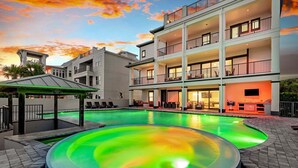 Un hôtel à plusieurs étages doté d’une piscine, d’un espace extérieur aménagé et d’une zone couverte.