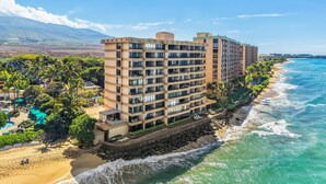 Ein Strandhotel mit mehreren Etagen, Balkonen und einem Poolbereich.