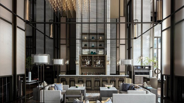 A modern interior with a bar area, seating, and a decorative chandelier. - Zhangjiagang Marriott Hotel (Suzhou)