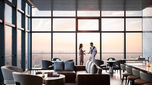 A modern hotel lobby with large windows, comfortable seating, and a city view. - Zhangjiagang Marriott Hotel (Suzhou)