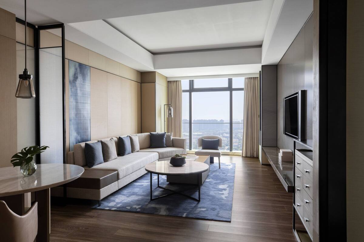 Una sala de estar moderna con sofá, mesa de centro y televisor.