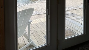 Une chambre avec vue sur une terrasse en bois et un lac.