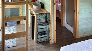 Une cuisine compacte aux murs en bois et dotée d’un espace nuit en mezzanine.