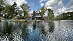Une propriété au bord du lac, avec des chalets, un quai et un ciel dégagé.