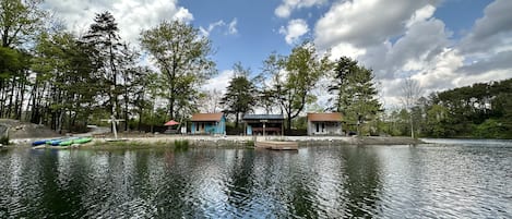 Ejendom ved en sø med hytter, en anløbsbro og en klar himmel.