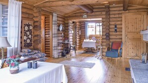 A log cabin interior with a dining area, a sofa, and a chair. - Nice home in Högsby with kitchen (Högsby)