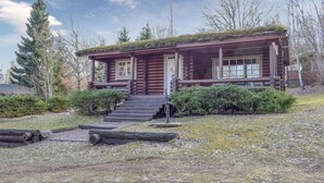 A log cabin with a porch and steps leading to the entrance. - Nice home in Högsby with kitchen (Högsby)