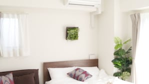 Quarto de hotel com cama, sofá, mesa de centro e planta em vaso.
