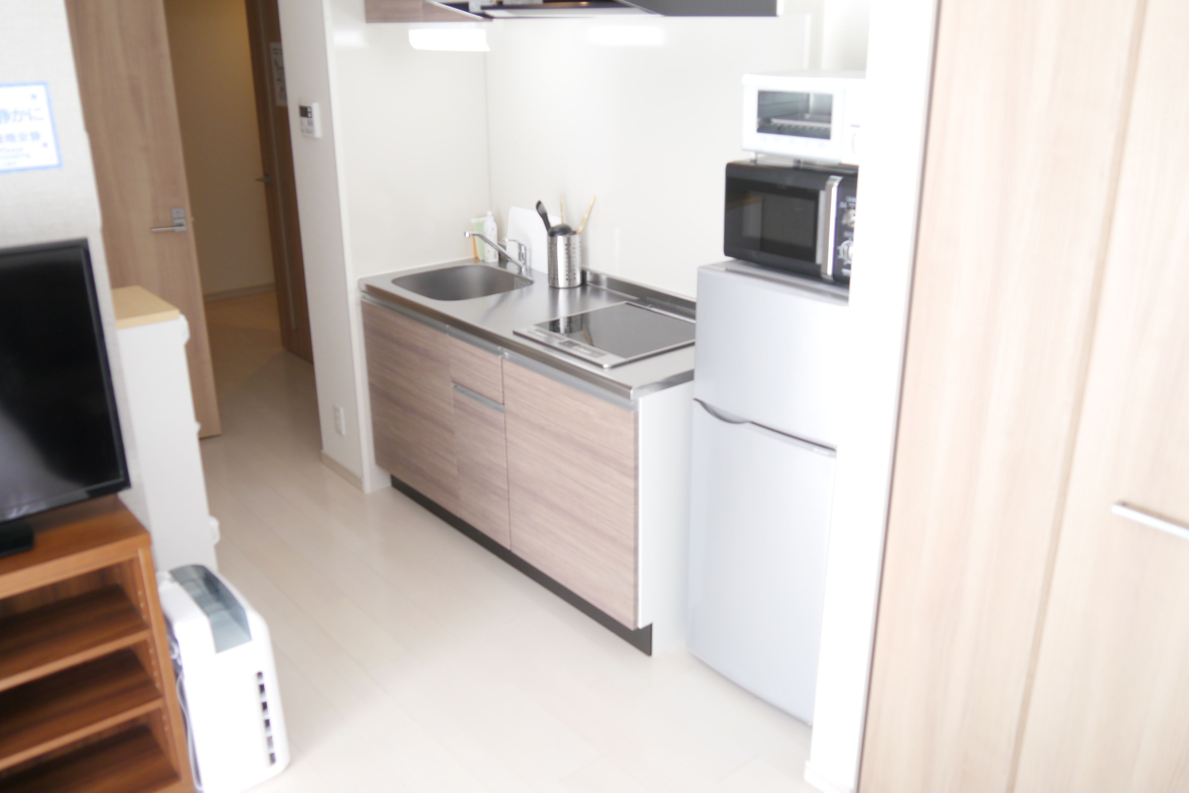A compact kitchen with a microwave, sink, and modern appliances.