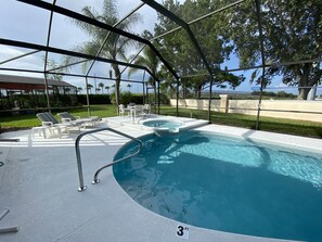 Une piscine extérieure couverte, dotée de chaises longues et d’un jacuzzi.