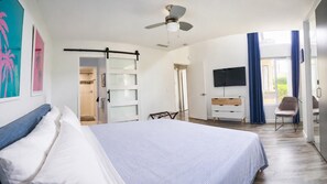 Une chambre à coucher avec un lit, une télévision, un bureau et une chaise.