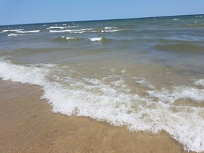 Une plage où les vagues viennent doucement lécher le rivage.