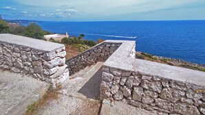 Un escalier en pierre menant à un point de vue surplombant la côte, d’où l’on peut admirer la mer.