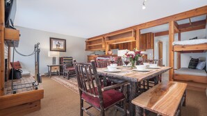 A rustic dining area with wooden furniture, a bench, and a table set for dining. - RMR: Chokeberry 3813 Condo in The Aspens (Wilson)