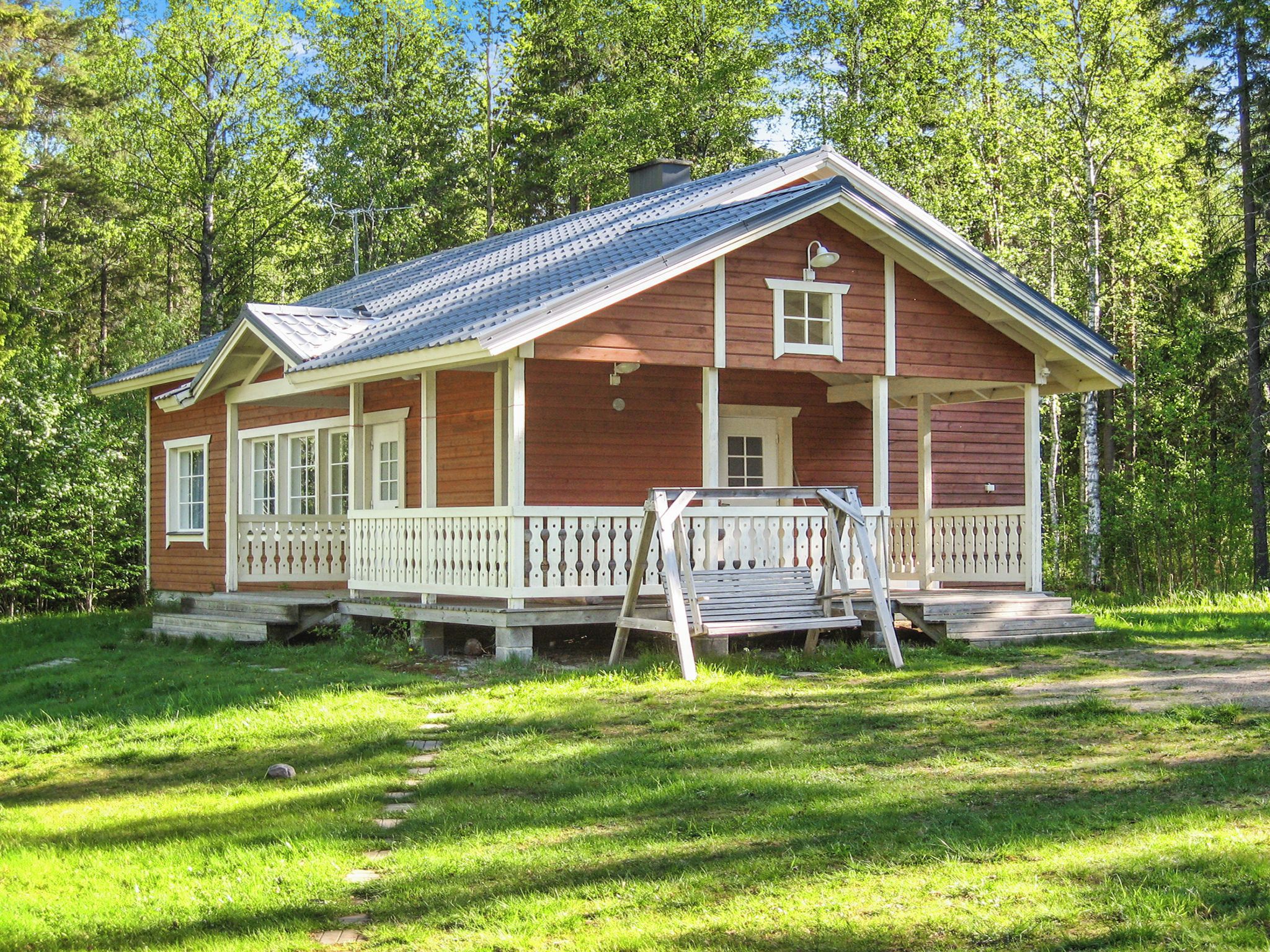 Eine Holzhütte mit Veranda, einer Haustür und einem kleinen Fenster.