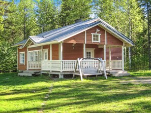 A wooden cabin with a porch, a front door, and a small window. - Kultaranta by Interhome (Juuka)