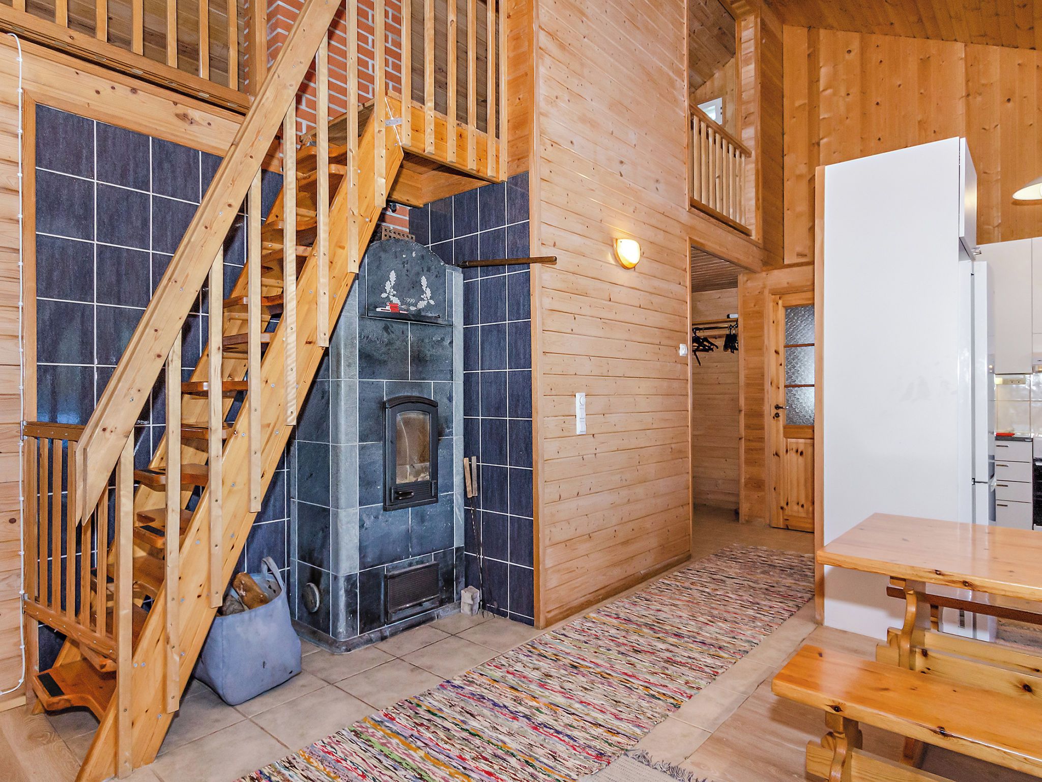 Un interior de madera con chimenea, una escalera y un comedor.