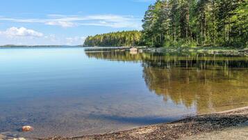 Um lago tranquilo com margens arborizadas e céu claro.
