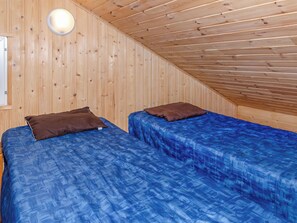 A room with two beds, each with a blue bedspread and a brown pillow. - Kultaranta by Interhome (Juuka)