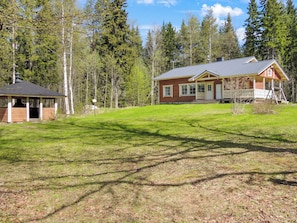 A two-story house with a porch and a small shed in a wooded area. - Kultaranta by Interhome (Juuka)
