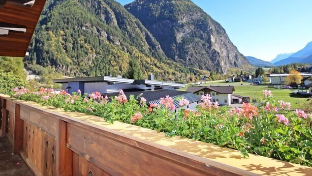 A mountain view with a wooden deck and flower beds. - Vacation home Dialer by Interhome (Umhausen)