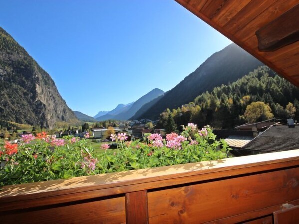 A wooden balcony with a view of a mountainous landscape, including a village and a valley. - Vacation home Dialer by Interhome (Umhausen)